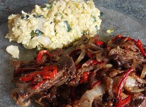 Una foto de Higadito salteado con cebolla y morrón acompañado con un revuelto de verduras y arroz