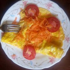 A picture of Fried eggs garnish with carrots and tomatoes.