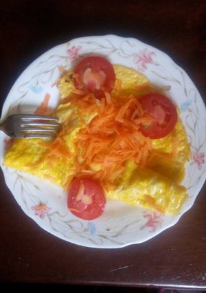 A picture of Fried eggs garnish with carrots and tomatoes.