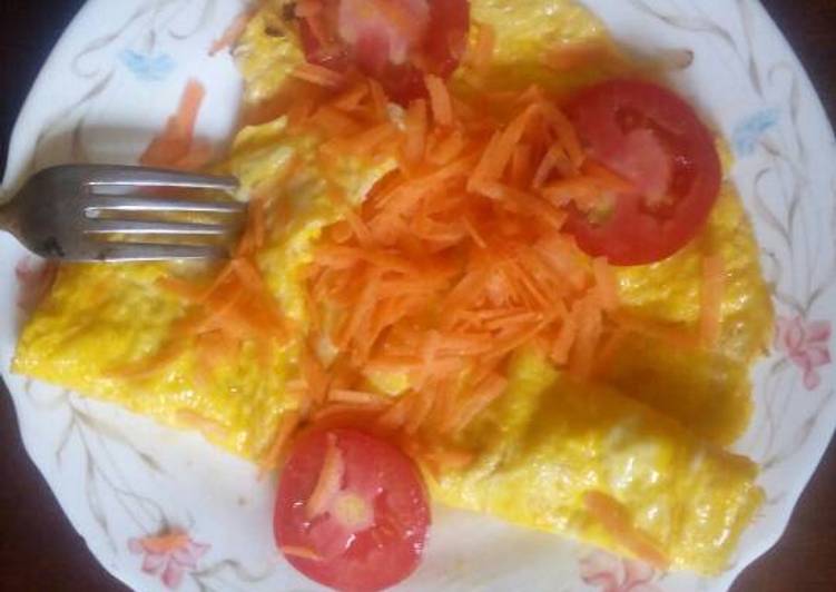 Fried eggs garnish with carrots and tomatoes