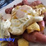 Huevos sobre fritada de salchichas y patatas