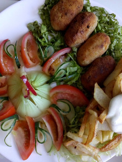Una foto de Croquetas de zanahoria con ensalada y unas papas fritas con alioli extra picante