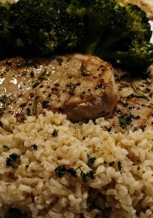A picture of Grilled Center-cut Pork Chops with Steamed Broccoli and Rice.