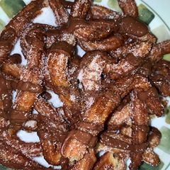 A picture of Churros with Sugar and Nutella.