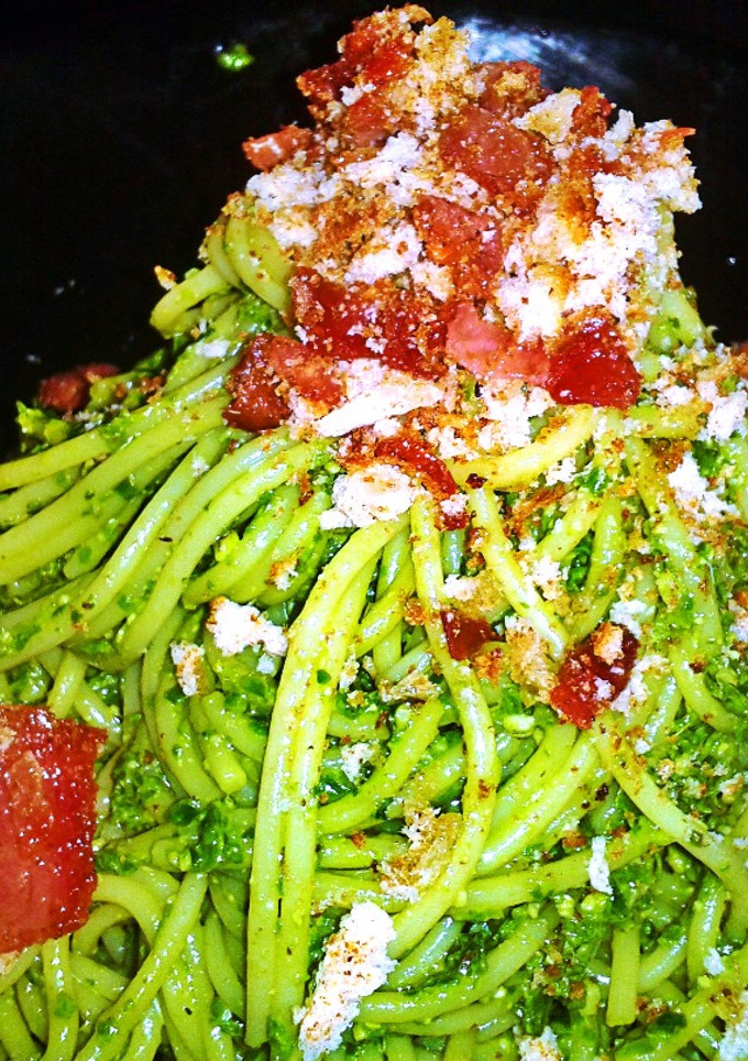 Una foto de Espaguetis con pesto de espinacas y crujiente de jamón serrano y pan al ajo