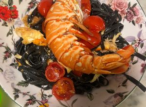 Foto di Tagliatelle al nero di seppia con aragosta al burro e pomodorini scottati