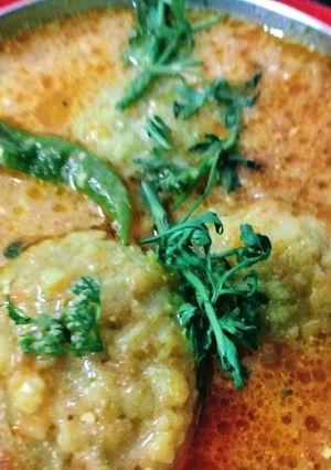 A picture of Besan tikki in Tomato and Curd gravy.