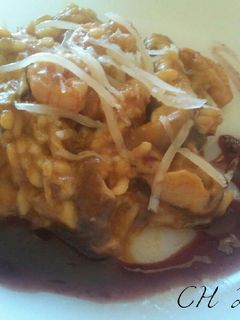 Una foto de Risotto de boletus y langostinos con coulis de mora