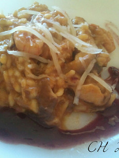 Una foto de Risotto de boletus y langostinos con coulis de mora