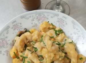 Una foto de ÑOQUIS soufflé con salsa de queso ciboulette