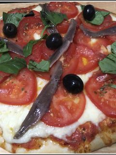 Una foto de Pizza con tomate y anchoas
