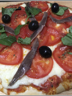 Una foto de Pizza con tomate y anchoas