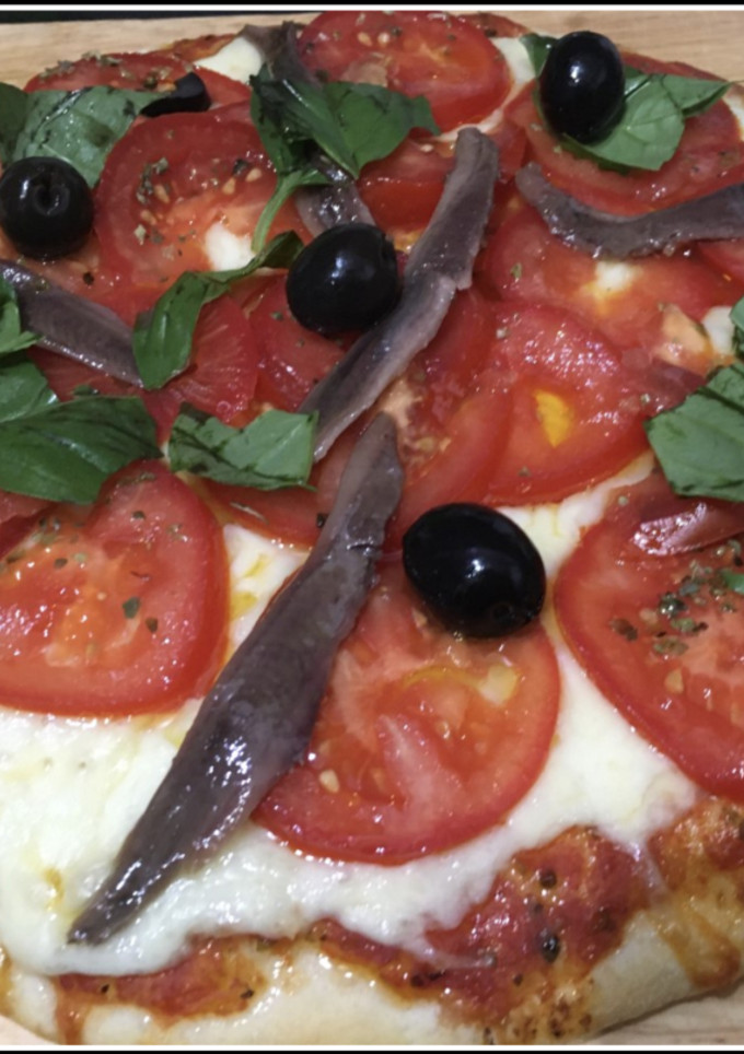 Una foto de Pizza con tomate y anchoas