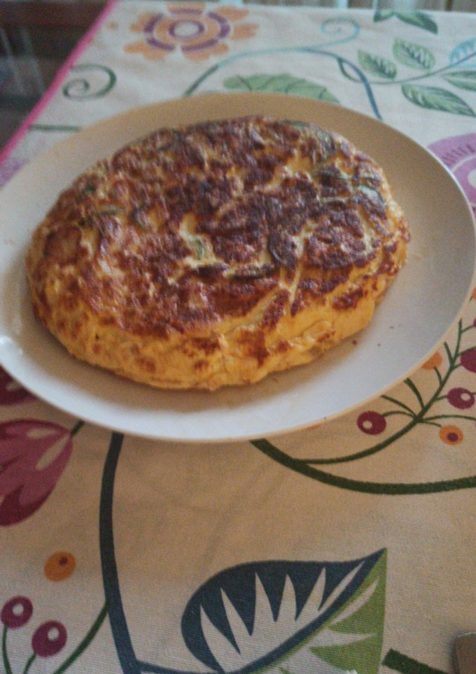 Una foto de Tortilla de calabacín, cebolla y tiras de bacon
