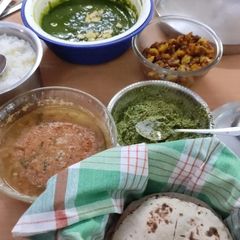 A picture of Pulka roti, peas palak panner, potato fry.