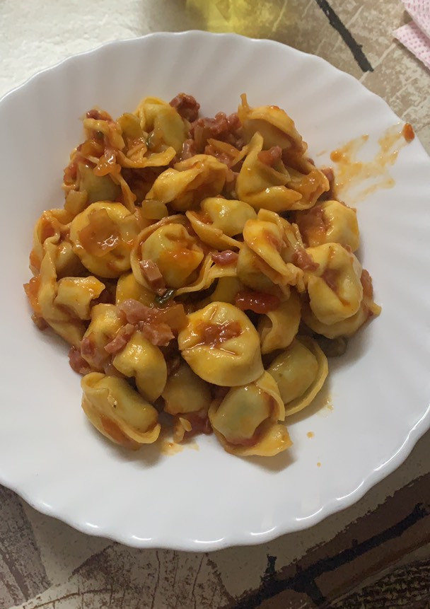Una foto de Tortellini con salsa de tomate y jamón serrano