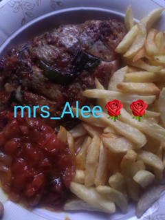 A picture of Chips, roasted fish and sauce.