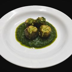 A picture of Stuffed eggplant with spinach gravy.