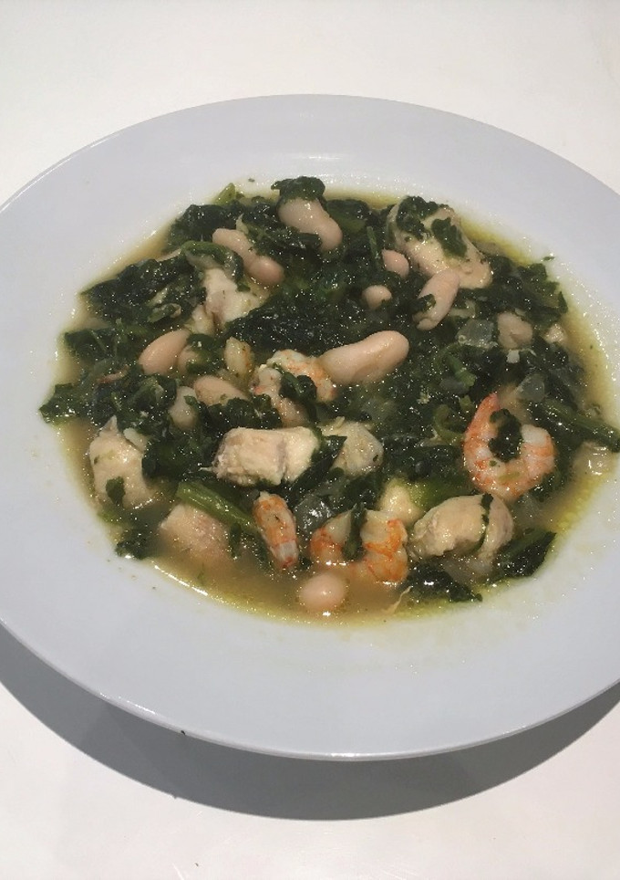 Una foto de Alubias con pescado y espinacas