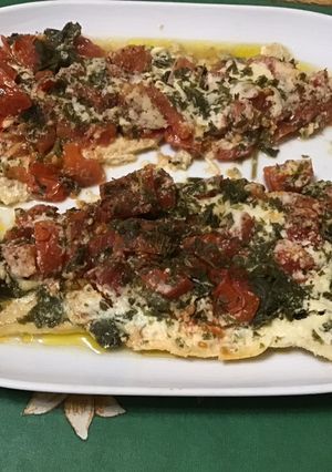 Une photo de Filets de loup de mer aux tomates, fanes de radis et parmesan