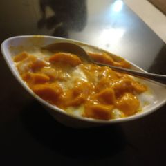 A picture of Vanilla ice cream with cut mango pieces.