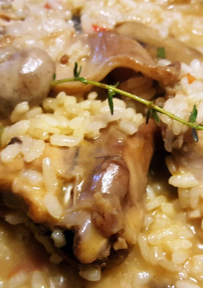 Una foto de Arroz caldoso con conejo y setas aromatizado con perejil y romero