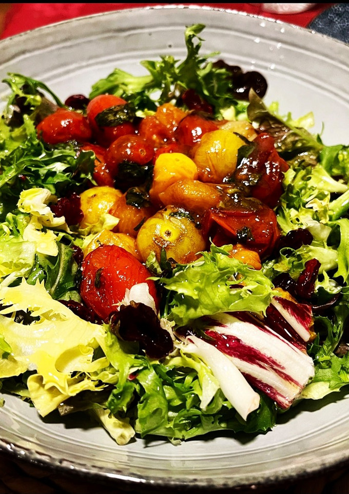 Una foto de Ensalada templada: tomatitos confitados y caramelizados con albahaca fresca y concentrado de Módena