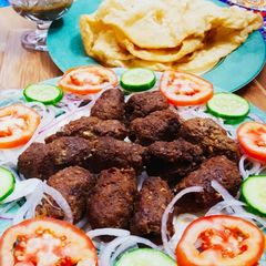 A picture of Beef gola kabab with puri paratha,salad chutney.