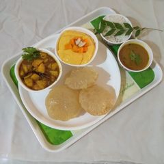 A picture of Gujarati lunch (rasadar aloo sabji, amrakhand, puri, dal, rice).