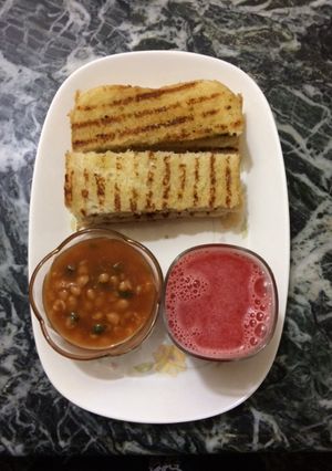 A picture of Baked beans with homemade garlic bread and fresh watermelon juice.