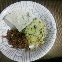 A picture of Cabbage garnished with dhania, wet fried omena and ugali.