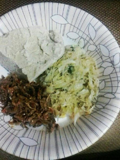 A picture of Cabbage garnished with dhania, wet fried omena and ugali.