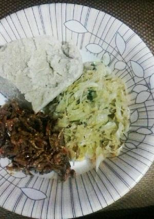 A picture of Cabbage garnished with dhania, wet fried omena and ugali.