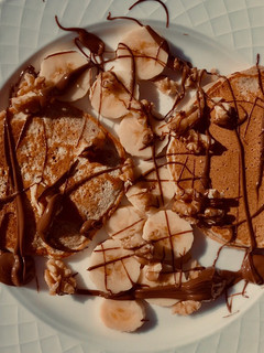 Una foto de Pancakes con plátano, Nutella y nueces