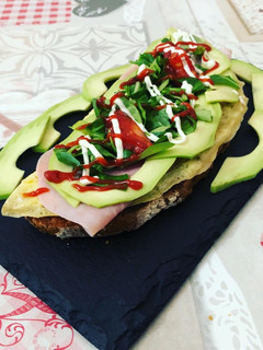 Una foto de Tostada de tortilla y jamón york, aguacate y canónigos