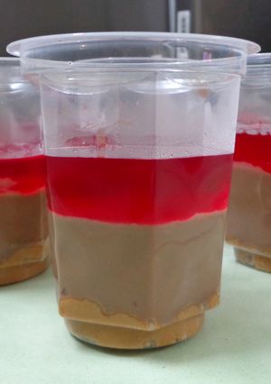 A picture of Peanut butter crumble, chocolate and raspberry jelly layered pudding.