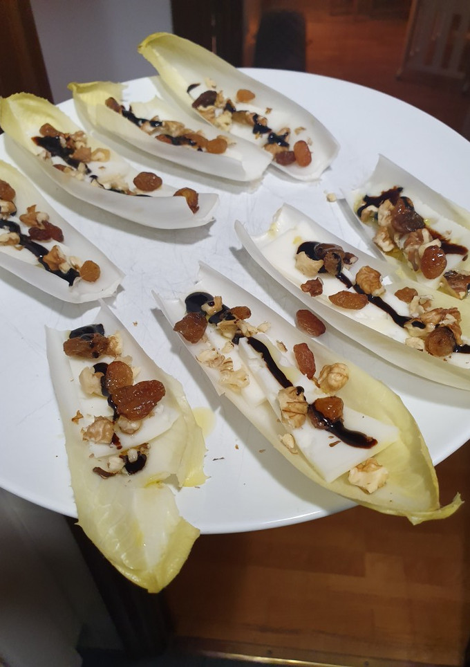 Una foto de Endibia con queso tierno, nueces, pasas, aove y vinagre de Módena