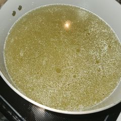 A picture of Pressure cooker chicken broth with frozen legs.
