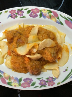 Una foto de Albóndigas de ternera en salsa sobre una cama de patatas fritas redondas