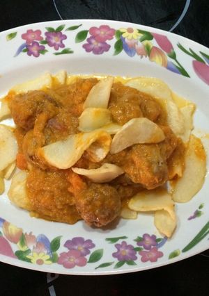 Una foto de Albóndigas de ternera en salsa sobre una cama de patatas fritas redondas