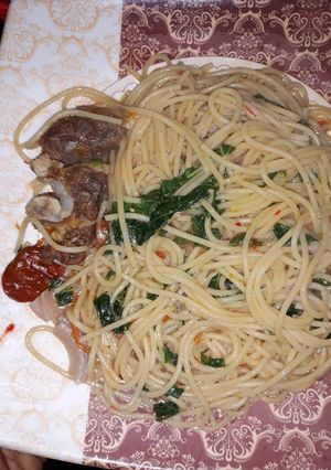 A picture of Spaghetti with green leaf.