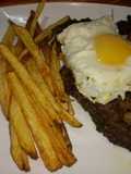 Bife de chorizo al ajillo a caballo con papas bravas