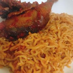 A picture of Jollof noodles and stewed chicken.