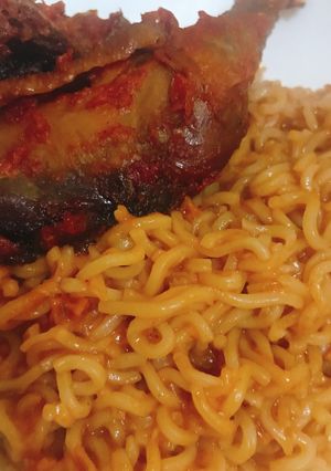 A picture of Jollof noodles and stewed chicken.