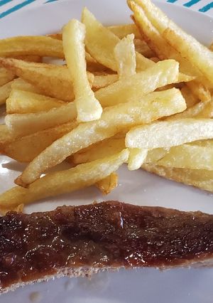 Una foto de Plateada al horno con papas fritas