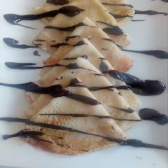 A picture of Crepes and chocolate sauce.