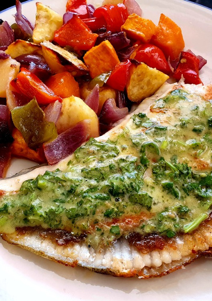 Una foto de Rodaballo con limón, cilantro y tahini y verduras asadas