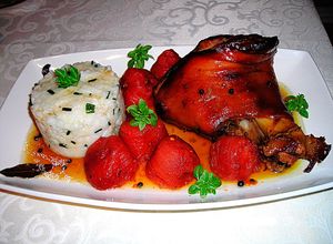 Una foto de Codillo de cerdo en el horno al cidra con tomates y arroz