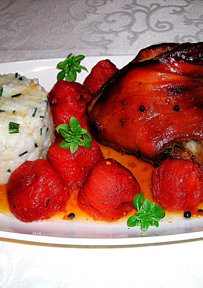 Una foto de Codillo de cerdo en el horno al cidra con tomates y arroz