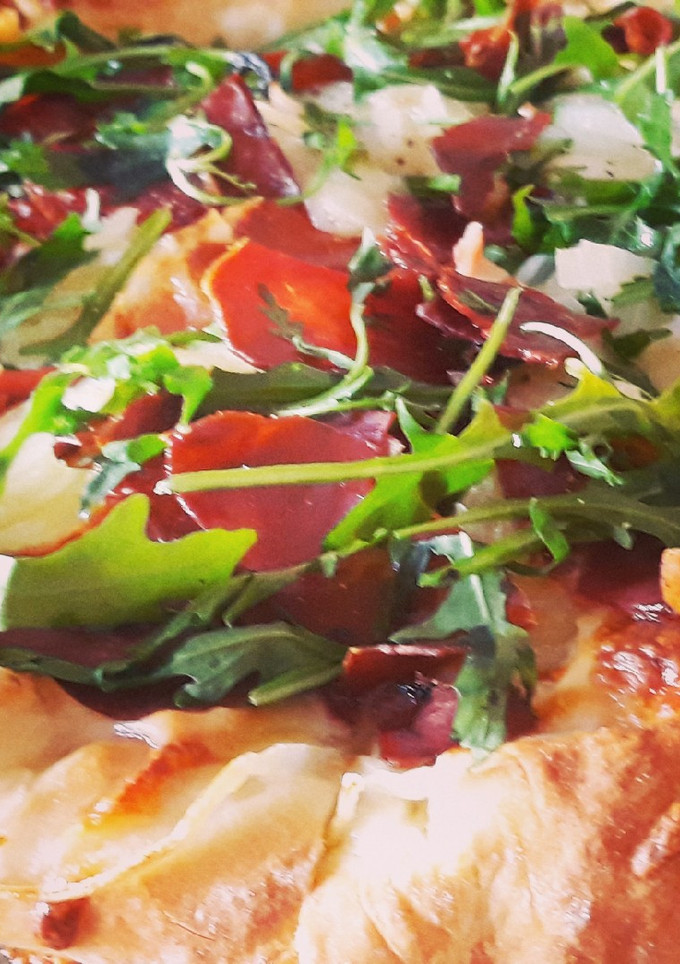 Una foto de Pizza de jamón y rúcula